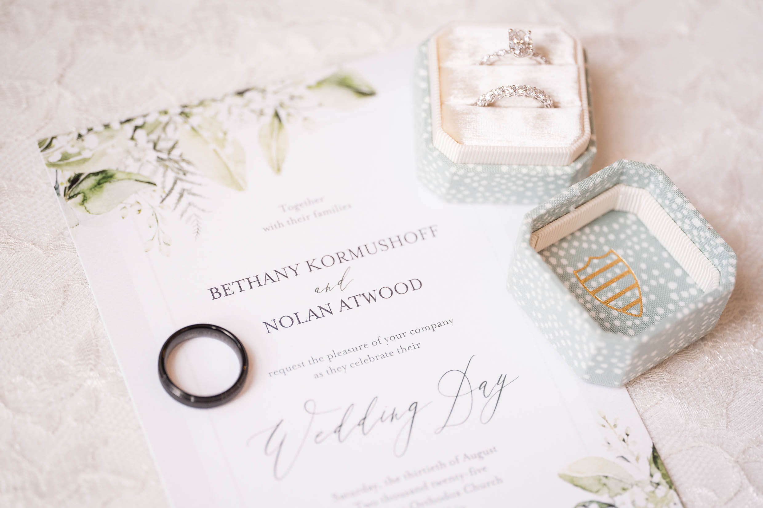 Close-up of wedding rings and invitation suite at elegant Akron wedding